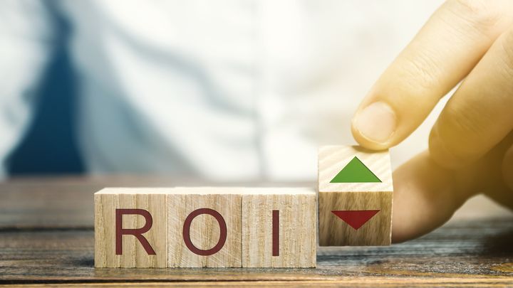 wooden blocks with the letters ROI and a green arrow pointing up